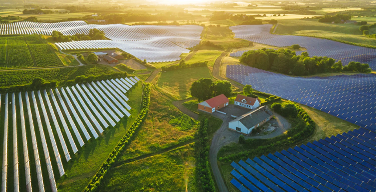 Aerial view of a solar farm and green farmland at golden hour in Europe