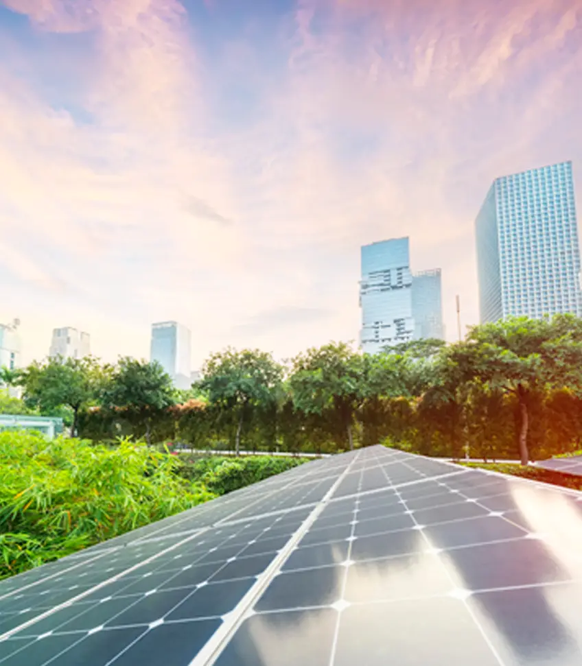 Solar panel in the foreground with city towers beyond